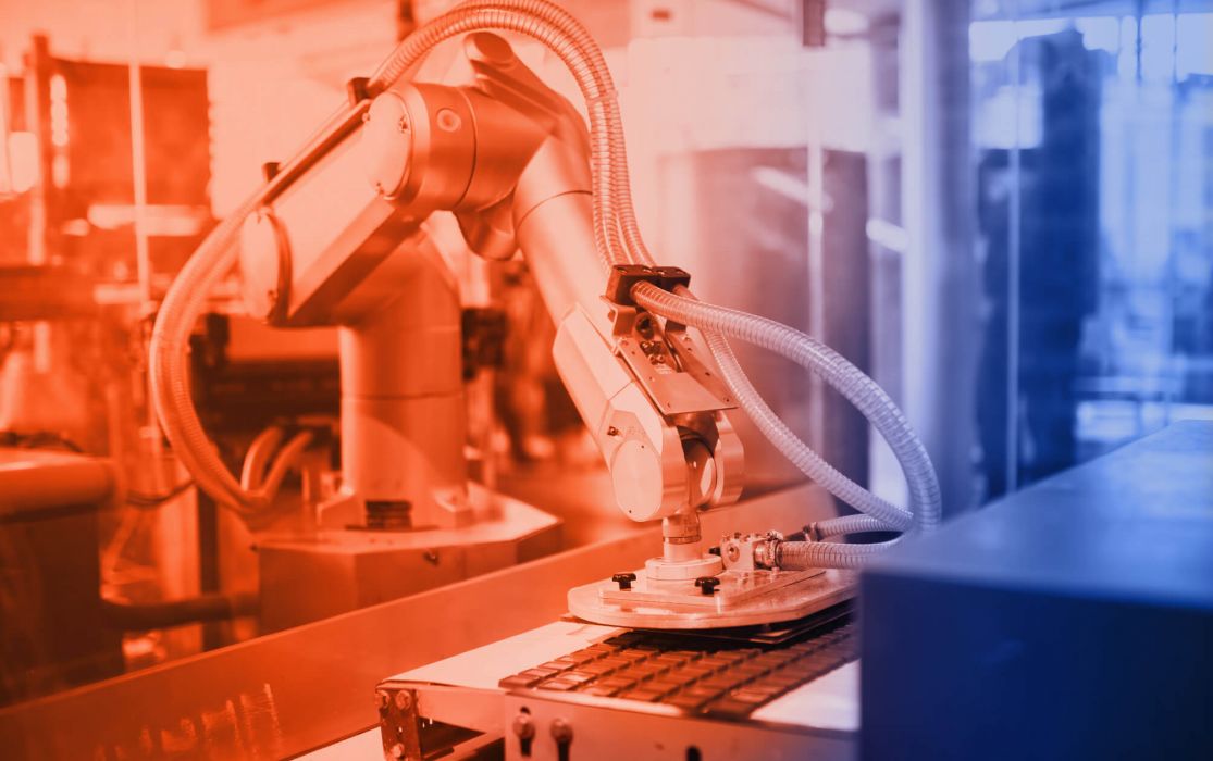 An industrial robot equipped with ELKALUB high-performance lubricants with hoses and a pneumatic device in food production. It reaches onto a conveyor belt and positions the chocolate bar.