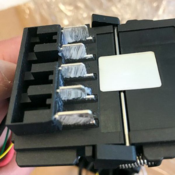 Darstellung einer mit ELKALUB behandelten Akkufahne, welche an einen Akkubohrer gesteckt wird.