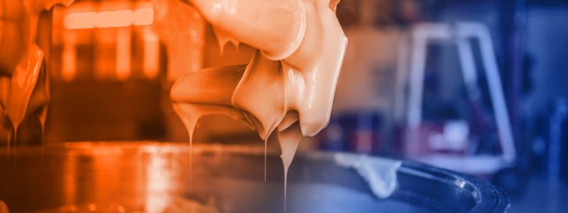 Grease production at ELKALUB. Close-up of a production machine with rotating mixing heads. These protrude from a mixing cylinder and are covered with lubricant.