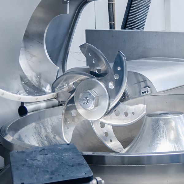 Darstellung eines mit ELKALUB H1-Schmierstoffen geschmierten Industrieschneiders in der Fleischindustrie..