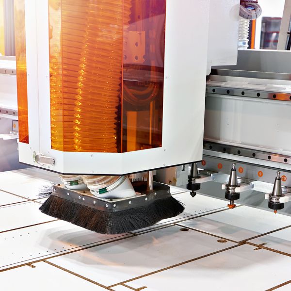 Darstellung einer mit ELKALUB geschmierten CNC-Anlage mit Greifern und Führung, mit der Holz gefräst wird