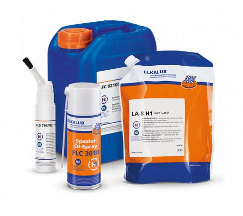 Eine Komposition verschiedener ELKALUB Gebinde. Abgebildet sind eine weiße Pinseldose mit ELKALUB GLS 794/N2, eine Dose Spezial-Öl-Spray FLC 3010, ein Schlauchbeutel mit LA 8 H1 und ein blauer 5-l-Kanister ELKALUB LFC 92100.
